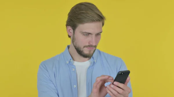 Casual Young Man Browsing Smartphone Yellow Background — Fotografia de Stock
