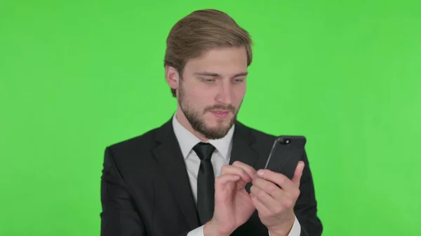 Young Adult Businessman Browsing Smartphone Green Background — 스톡 사진