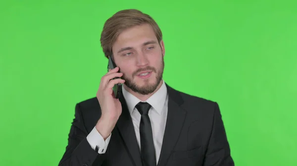 Молодий Дорослий Бізнесмен Говорить Телефону Зеленому Тлі — стокове фото