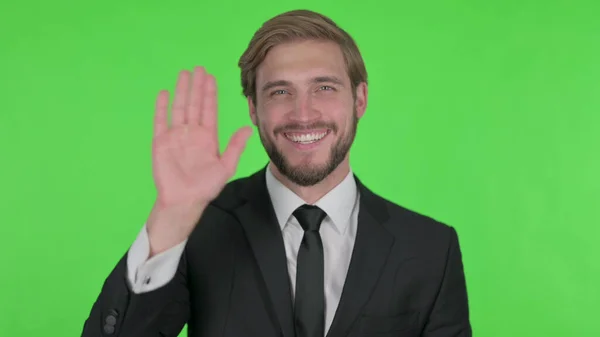 Young Adult Businessman Waving Hand Say Hello Green Background — стокове фото