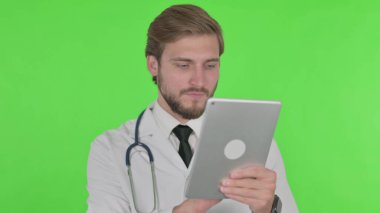 Young Adult Doctor using Digital Tablet on Green Background