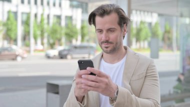 Man Browsing Internet on Smartphone Outdoor