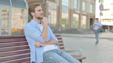 Düşünceli Orta yaşlı adam Bench 'te otururken düşünüyor.