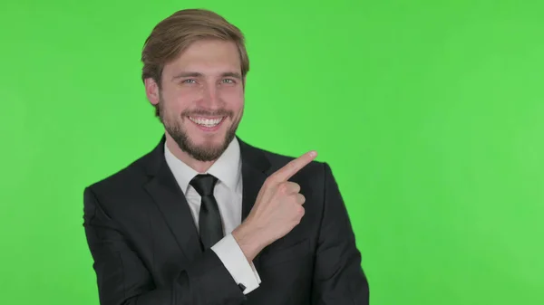 Young Adult Businessman Pointing Side Green Background — 스톡 사진