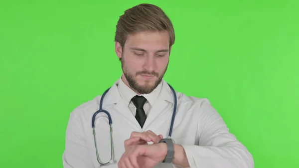 Young Adult Doctor Using Smartwatch Green Background — Zdjęcie stockowe