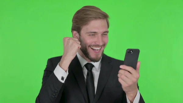 Young Adult Businessman Celebrating Smartphone Green Background — Stockfoto