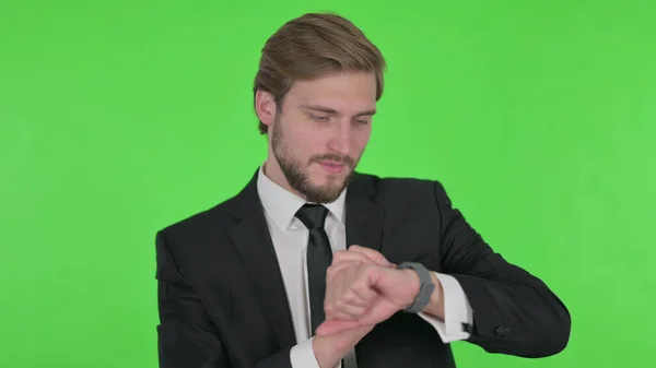 Young Adult Businessman Using Smartwatch Green Background — 스톡 사진