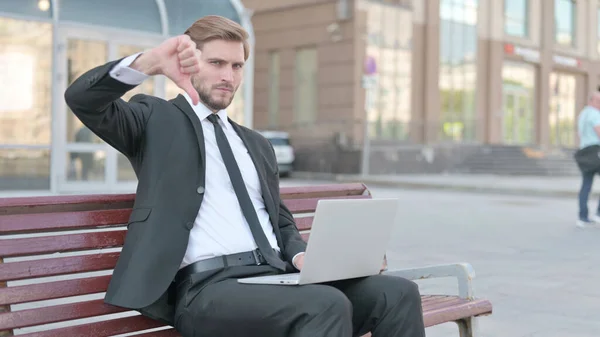 Thumbs Down by Businessman with Laptop Sitting on Bench