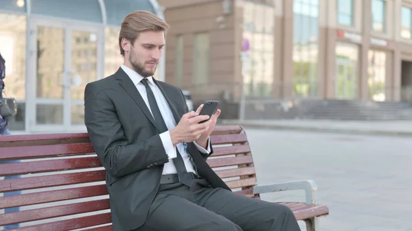 Middle Aged Businessman Browsing Internet Smartphone While Sitting Outdoor Bench — Stock fotografie