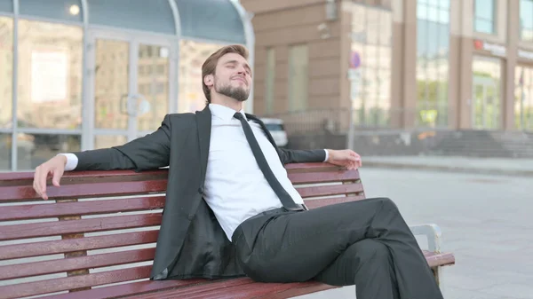 Pensive Middle Aged Businessman Thinking while Sitting Outdoor on Bench