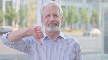 Thumbs Down By Senior Old Man Standing Outdoor