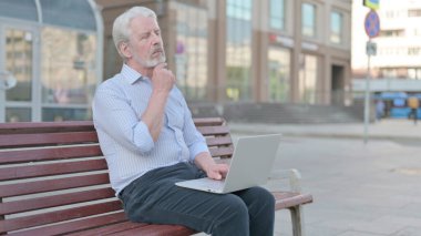 Thinking Senior Old Man Using Laptop while Sitting Outdoor on Bench