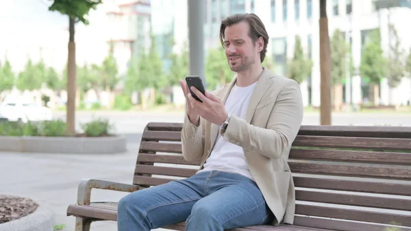 Man Reacting Loss Smartphone While Sitting Bench — Zdjęcie stockowe