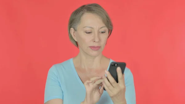 Senior Old Woman Browsing Smartphone Red Background — 스톡 사진