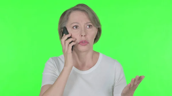 Старша Стара Жінка Розсердилася Телефоні Зеленому Тлі — стокове фото
