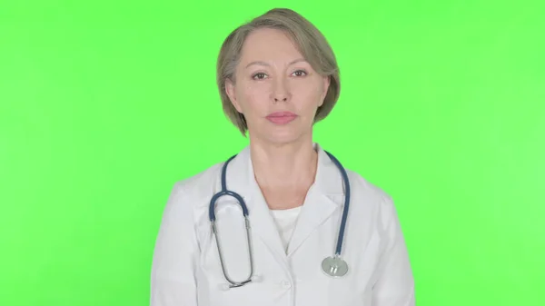 Serious Senior Female Doctor Green Background — 스톡 사진