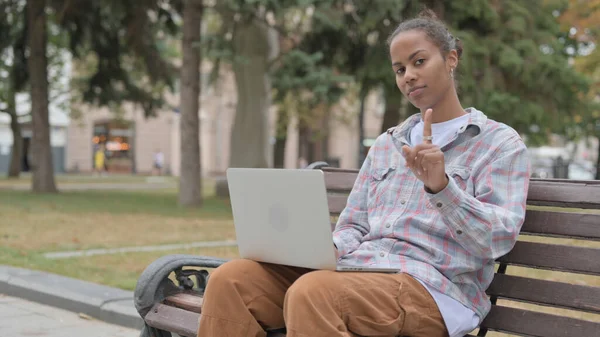 Rejecting Young African Woman in Denial While using Laptop Sitting Outdoor on Bench