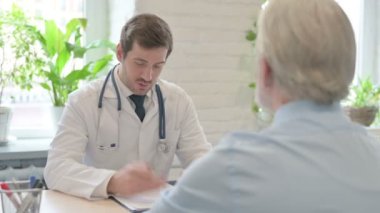 Genç Doktor Klinikteki Yaşlı Hastayla Konuşuyor