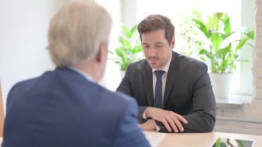 Yaşlı işadamı kıdemli iş adamıyla konuşuyor.