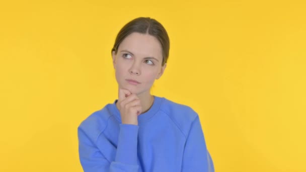 黄色の背景にカジュアルな女性の思考のアイデアをブレーンストーミング — ストック動画