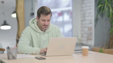 Thumbs Up by Young Adult Man Working on Laptop