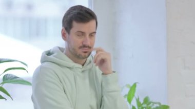 Thinking Young Adult Man Standing Near Window