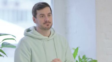 Young Adult Man with Headache, Migraine while Standing Near Window