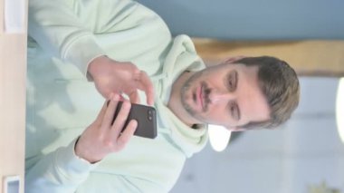 Vertical Video of Young Adult Man Browsing Internet on Smartphone