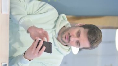 Vertical Video of Young Adult Man Celebrating Success on Smartphone
