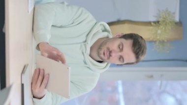 Vertical Video of Young Adult Man using Digital Tablet