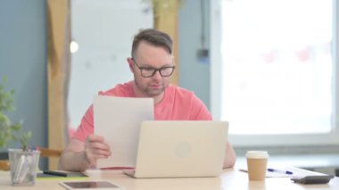 Young Adult Man Working on Laptop and Documents