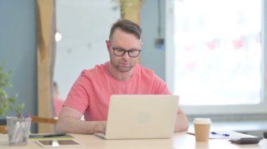 Young Adult Man Leaving Office after Closing Laptop