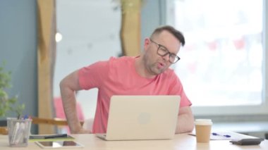 Young Adult Man having Back Pain while using Laptop