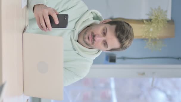 Vertical Video Young Adult Man Using Smartphone Laptop — Vídeo de stock