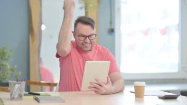 Young Adult Man Cheering Win on Digital Tablet