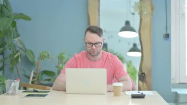 Creative Senior Old Man Shaking Head in Rejection while Working on Laptop