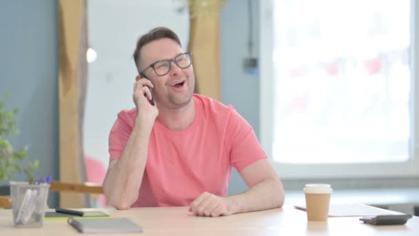 若い大人の男がオフィスで電話で話している — ストック動画