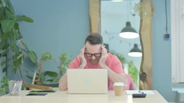 Creative Senior Old Man having Headache while Working on Laptop