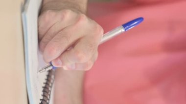 Vertical Video of Male Hand Writing while Sitting in Office