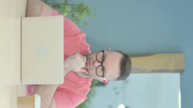 Vertical Video of Pensive Senior Old Man Working on Laptop