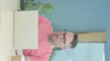 Vertical Video of Senior Old Man Shocked by Loss on Laptop