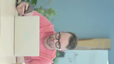 Vertical Video of Senior Old Man Using Smartphone and Laptop