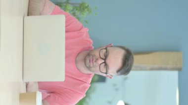 Vertical Video of Senior Old Man Smiling at Camera while using Laptop