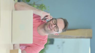 Vertical Video of Senior Old Man Talking on Phone at Work