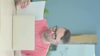 Vertical Video of Senior Old Man Working on Laptop and Documents