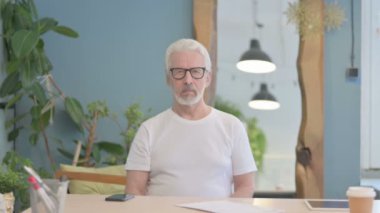 Senior Old Man showing Thumbs Down at Work