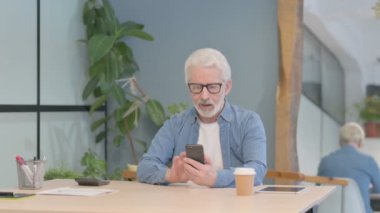 Successful Senior Old Man Celebrating Win on Smartphone