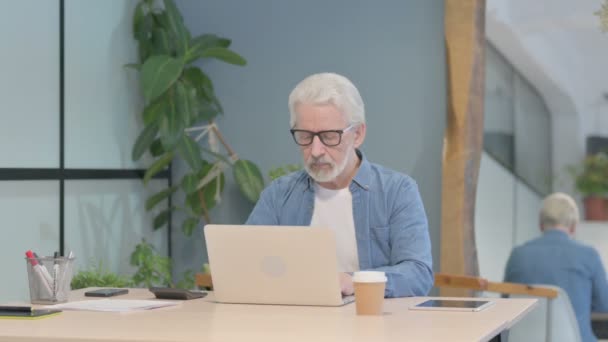 Senior Old Man Κοιτάζοντας Την Κάμερα Ενώ Χρησιμοποιείτε Laptop — Αρχείο Βίντεο