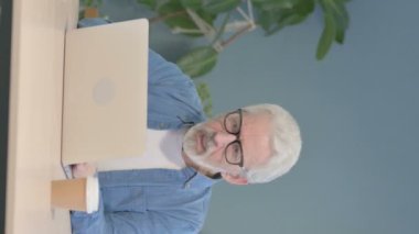 Vertical Video of Senior Old Man Reacting to Online Loss on Laptop
