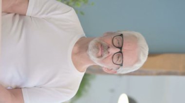 Vertical Video of Senior Old Man Pointing at the Camera in Office